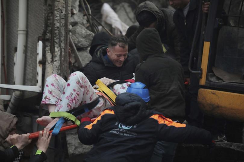 People rescue a woman from the debris in Iskenderun, southern Turkey, Monday, Feb. 6, 2023. A powerful earthquake that struck southeast Turkey and northern Syria has killed more than 640 people with hundreds injured. The toll is expected to rise as rescuers search for dead and survivors in dozens of collapsed buildings across the region. (Depo Photos via AP)