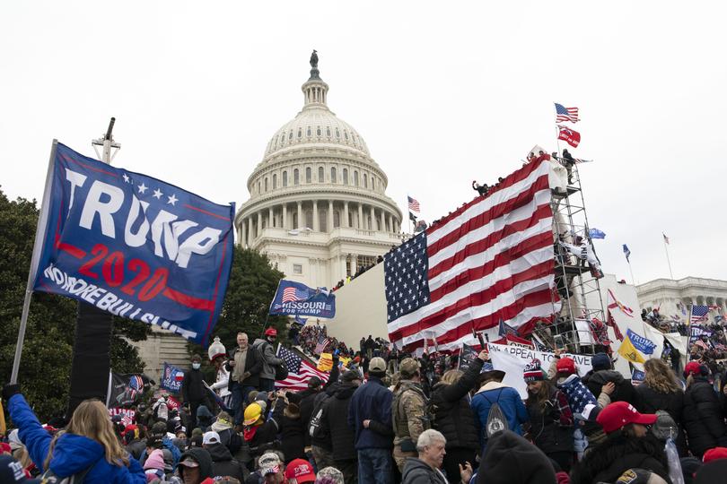 FILE - Violent insurrectionists loyal to President Donald Trump stand outside the U.S. Capitol in Washington on Jan. 6, 2021. The public hearings of the House committee investigating the insurrection pose a challenge to Democrats seeking to maintain narrow control of Congress. (AP Photo/Jose Luis Magana, File)