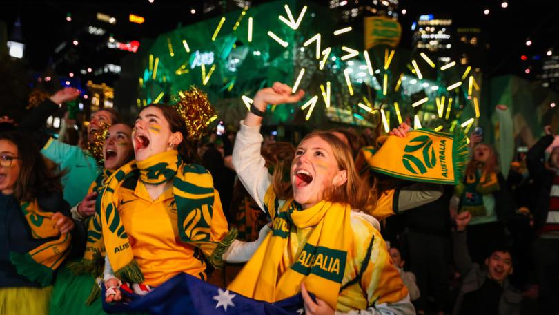 MELBOURNE, AUSTRALIA - AUGUST 07: Australian fans celebrate at Melbourne's Federation Square after watching the Matildas FIFA World Cup win their round of 16 match against Denmark, being played in Sydney, on August 07, 2023 in Melbourne, Australia. (Photo by Asanka Ratnayake/Getty Images) Asanka Ratnayake