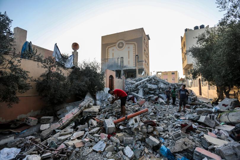 People search through buildings that were destroyed during Israeli air raids in the southern Gaza Strip.