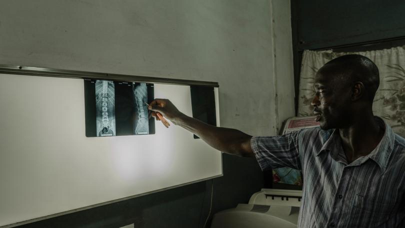 Richard Wonu, a radiographer, interprets a patient’s scans at the Kaneshie Polyclinic in Accra, Ghana, Oct. 24, 2023.  