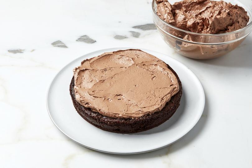 Chocolate layer cake. Dolloping a bit of frosting on the plate will help keep your first cake layer in place. Food styled by Laurie Ellen Pellicano. (Joseph De Leo/The New York Times)