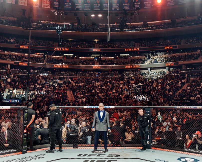 Bruce Buffer, Ultimate Fighting Championship’s official announcer, stands in the octagon fighting ring at Madison Square Garden in New York, Nov. 11, 2023. Buffer, known for his baritone growl and ability to fire up the crowd with his “It’s time!” catchphrase, crouches, twists and spins in the caged octagon, has seen his status balloon as the UFC evolved from a ragtag fighting league into a corporate behemoth. (Thomas Prior/The New York Times)