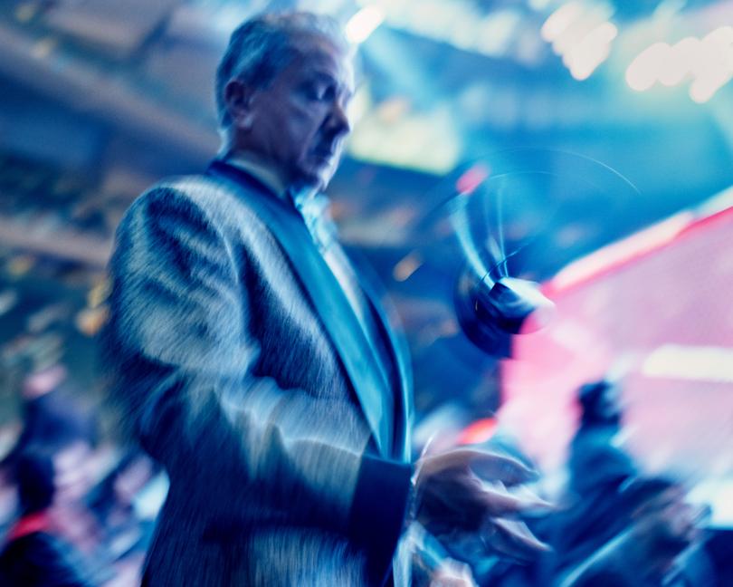 Bruce Buffer, Ultimate Fighting Championship’s official announcer, flips his microphone during an evening of fights at Madison Square Garden in New York, Nov. 11, 2023. Buffer, known for his baritone growl and ability to fire up the crowd with his “It’s time!” catchphrase, crouches, twists and spins in the caged octagon, has seen his status balloon as the UFC evolved from a ragtag fighting league into a corporate behemoth. (Thomas Prior/The New York Times)