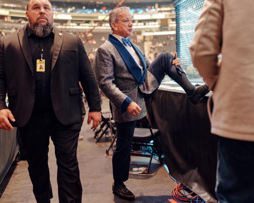 Bruce Buffer, Ultimate Fighting Championship’s official announcer, limbers up before working an evening of fights at Madison Square Garden in New York, Nov. 11, 2023. Buffer, known for his baritone growl and ability to fire up the crowd with his “It’s time!” catchphrase, crouches, twists and spins in the caged octagon, has seen his status balloon as the UFC evolved from a ragtag fighting league into a corporate behemoth. (Thomas Prior/The New York Times)