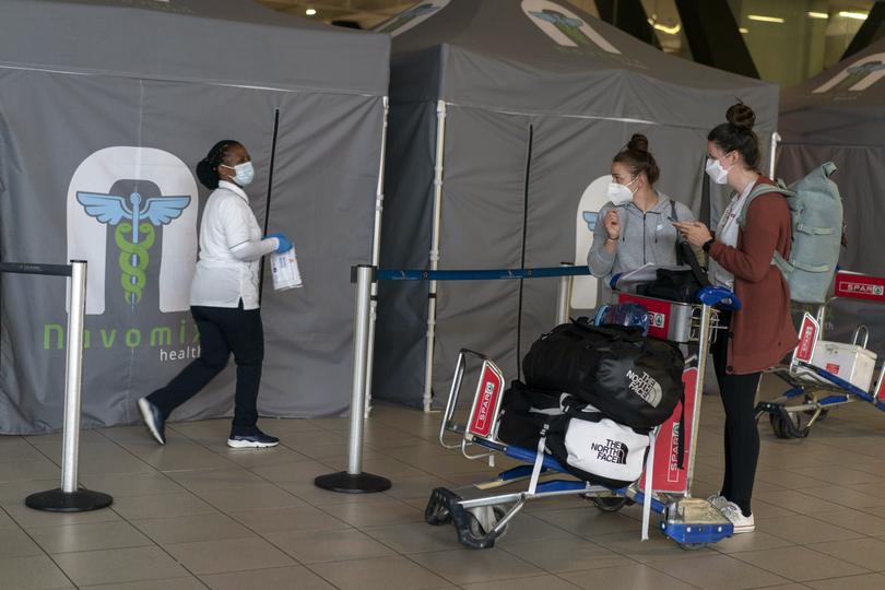  EMBARGO: NO ELECTRONIC DISTRIBUTION, WEB POSTING OR STREET SALES BEFORE 3:01 A.M. ET ON TUESDAY, NOV. 21, 2023. NO EXCEPTIONS FOR ANY REASONS   FILE  Travelers at O.R. Tambo International Airport in Johannesburg on Nov. 27, 2021, as travel bans were imposed on people coming from South Africa because of Omicron. The dominant variant of the coronavirus has proved to be not only staggeringly infectious, but an evolutionary marvel. (Joao Silva/The New York Times) 