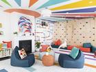 A ceiling painted with a mural and colorful monkey bars brighten up this space by grOH! Playrooms. 