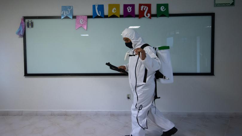 Cleaning staff sanitise a classroom at the Motolinia University school during the return to in person classes in Mexico on August 30, 2021.