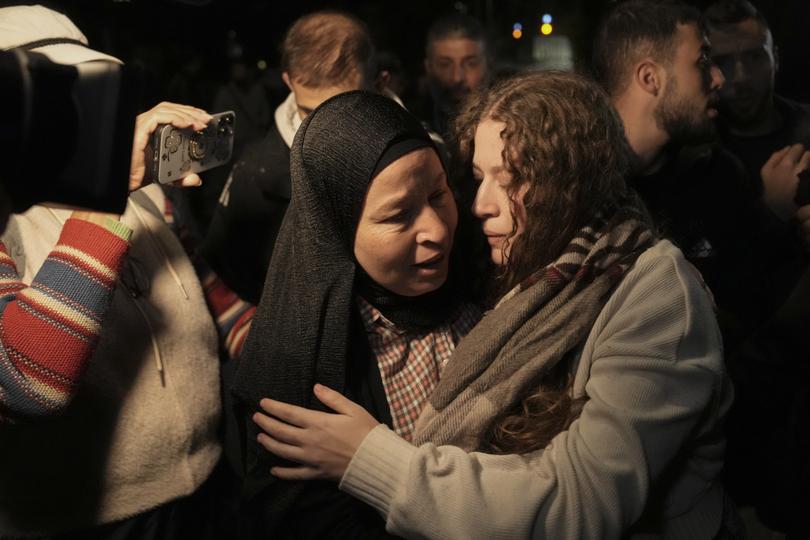 Palestinian activist Ahed Tamimi, right, is greeted by her mother after she was released from prison by Israel, in the West Bank town of Ramallah, early Thursday, Nov. 30, 2023. International mediators on Wednesday worked to extend the truce in Gaza, encouraging Hamas militants to keep freeing hostages in exchange for the release of Palestinian prisoners and further relief from Israel's air and ground offensive. (AP Photo/Nasser Nasser)