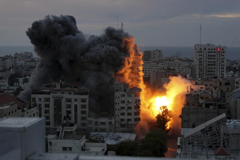 A ball of fire and smoke rise from an explosion on a Palestinian apartment tower following an Israeli air strike in Gaza City, Saturday, Oct. 7, 2023. 