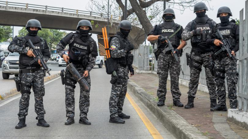 Police officers carry out an operation at the headquarters of TC television station where armed, hooded men entered and subdued staff during a live broadcast.