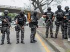 Police officers carry out an operation at the headquarters of TC television station where armed, hooded men entered and subdued staff during a live broadcast.