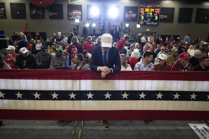 A supporter waits for former President Donald Trump to arrive at a commit to caucus rally, Saturday, Jan. 6, 2024, in Clinton, Iowa. (AP Photo/Charlie Neibergall)