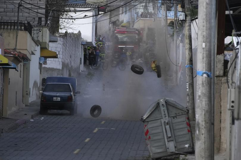 Police carry out a controlled explosion of a suspicious vehicle, left abandoned and parked a block from El Inca prison, in Quito, Ecuador, Wednesday, Jan. 10, 2024. (AP Photo/Carlos Noriega)