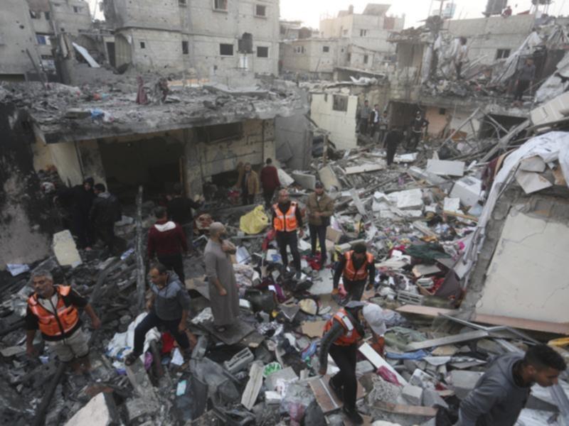 Palestinians look for survivors of an Israeli bombardment in Rafah