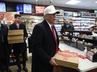 Donald Trump carries pizza at a Casey's in Waukee, Iowa, Sunday, Jan. 14, 2024. 