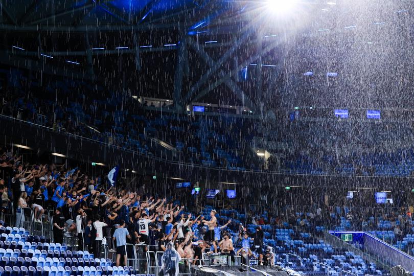 SYDNEY, AUSTRALIA - DECEMBER 02: Sydney FC fans dance in the rain as play is delayed due to storms and ightning in the immediate area during the A-League Men round six match between Sydney FC and Perth Glory at Allianz Stadium, on December 02, 2023, in Sydney, Australia. (Photo by Mark Evans/Getty Images)