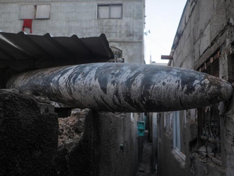 An unexploded Israeli missile lodged between two houses of Al Nusairat refugee camp. (EPA PHOTO)