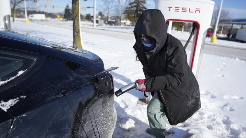 Ankita Bansal prepares to charge her Tesla, Wednesday, Jan. 17, 2024, in Ann Arbor, Mich.