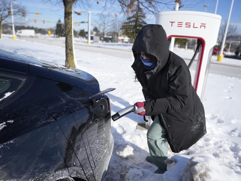 Ankita Bansal prepares to charge her Tesla, Wednesday, Jan. 17, 2024, in Ann Arbor, Mich.