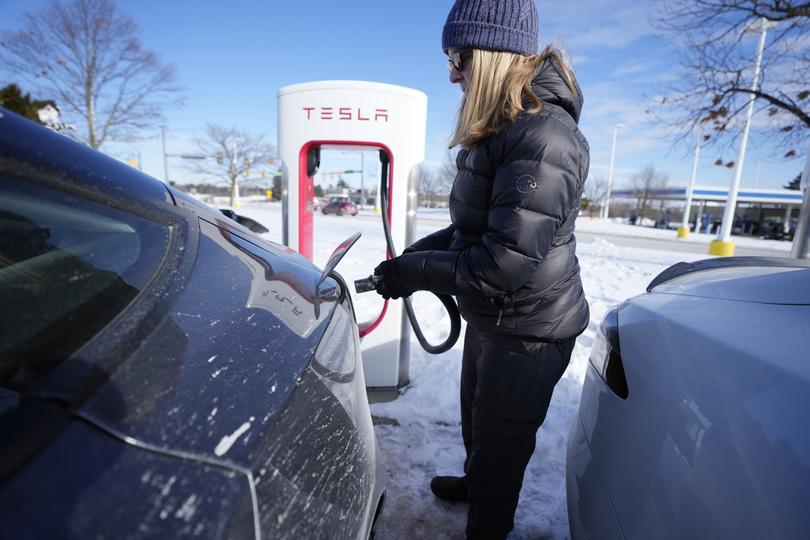 Kim Burney charges her Tesla, Wednesday, Jan. 17, 2024, in Ann Arbor, Mich. A subzero cold snap across the nation has exposed a big vulnerability for electric vehicle owners. It's difficult to charge the batteries in single-digit temperatures. Experts say it's simple chemistry, that the electrons move slowly and don't take in or release as much energy.(AP Photo/Carlos Osorio)