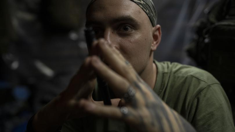 A Ukrainian soldier sits inside a trench on the frontline in the outskirts of Lyman, Ukraine, Tuesday, Aug. 15, 2023.