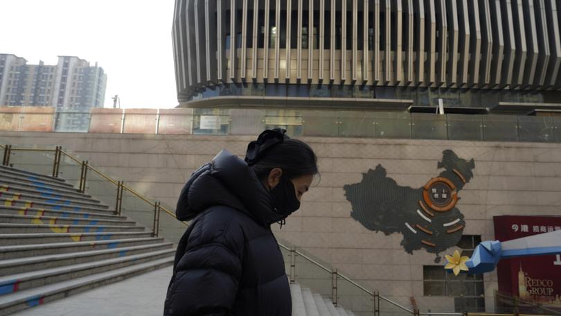 A woman walks through a partially shuttered Evergrande commercial complex in Beijing, Monday, Jan. 29, 2024. Chinese property developer China Evergrande Group on Monday was ordered to liquidate by a Hong Kong court, after the firm was unable to reach a restructuring deal with creditors. (AP Photo/Ng Han Guan)