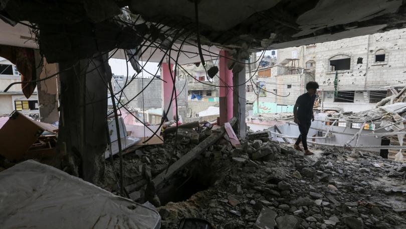 People search through buildings that were destroyed during Israeli air raids in the southern Gaza Strip. 