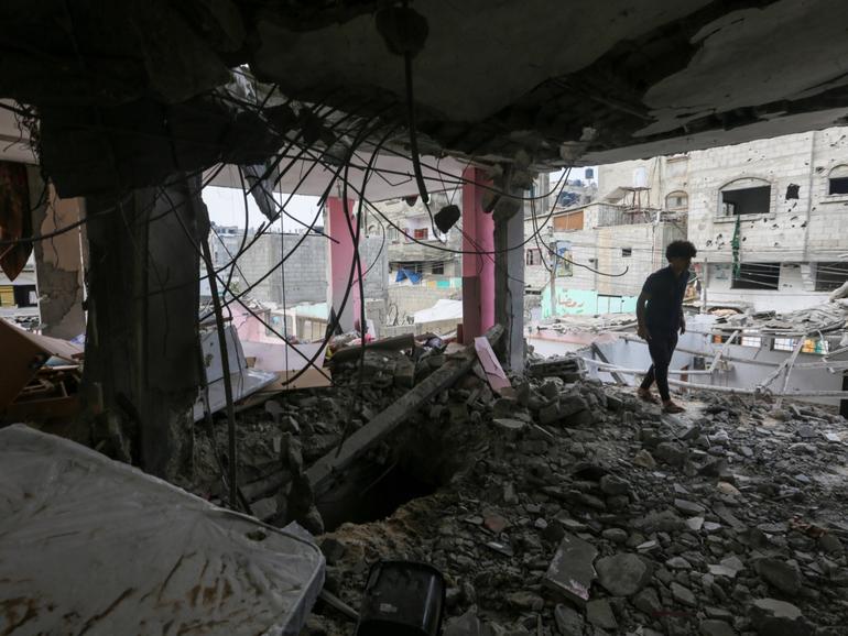 People search through buildings that were destroyed during Israeli air raids in the southern Gaza Strip. 