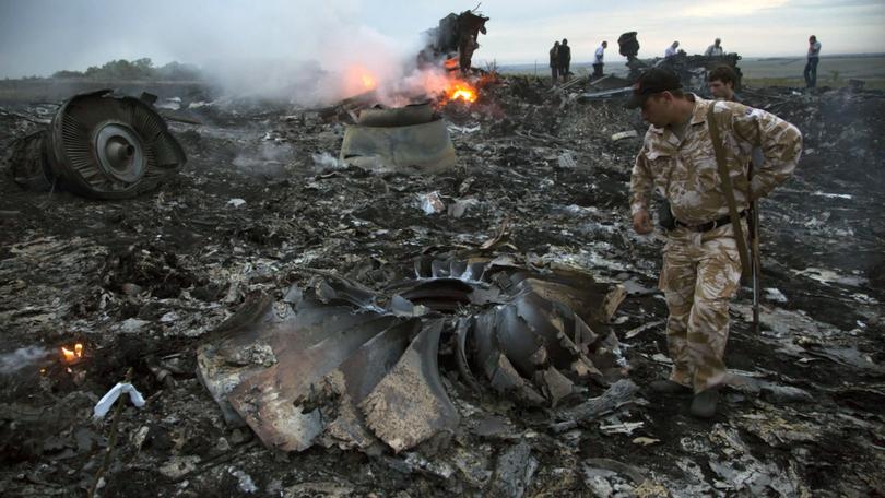 People walk amongst the debris at the crash site of MH17 in the Ukraine in 2014. (AP Photo/Dmitry Lovetsky, File)