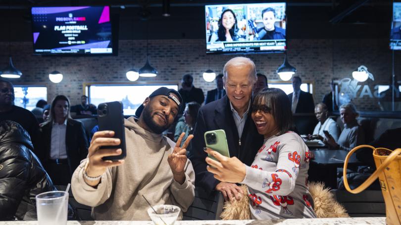 President Joe Biden takes photos with patrons during a campaign stop Thursday, Feb. 1, 2024.