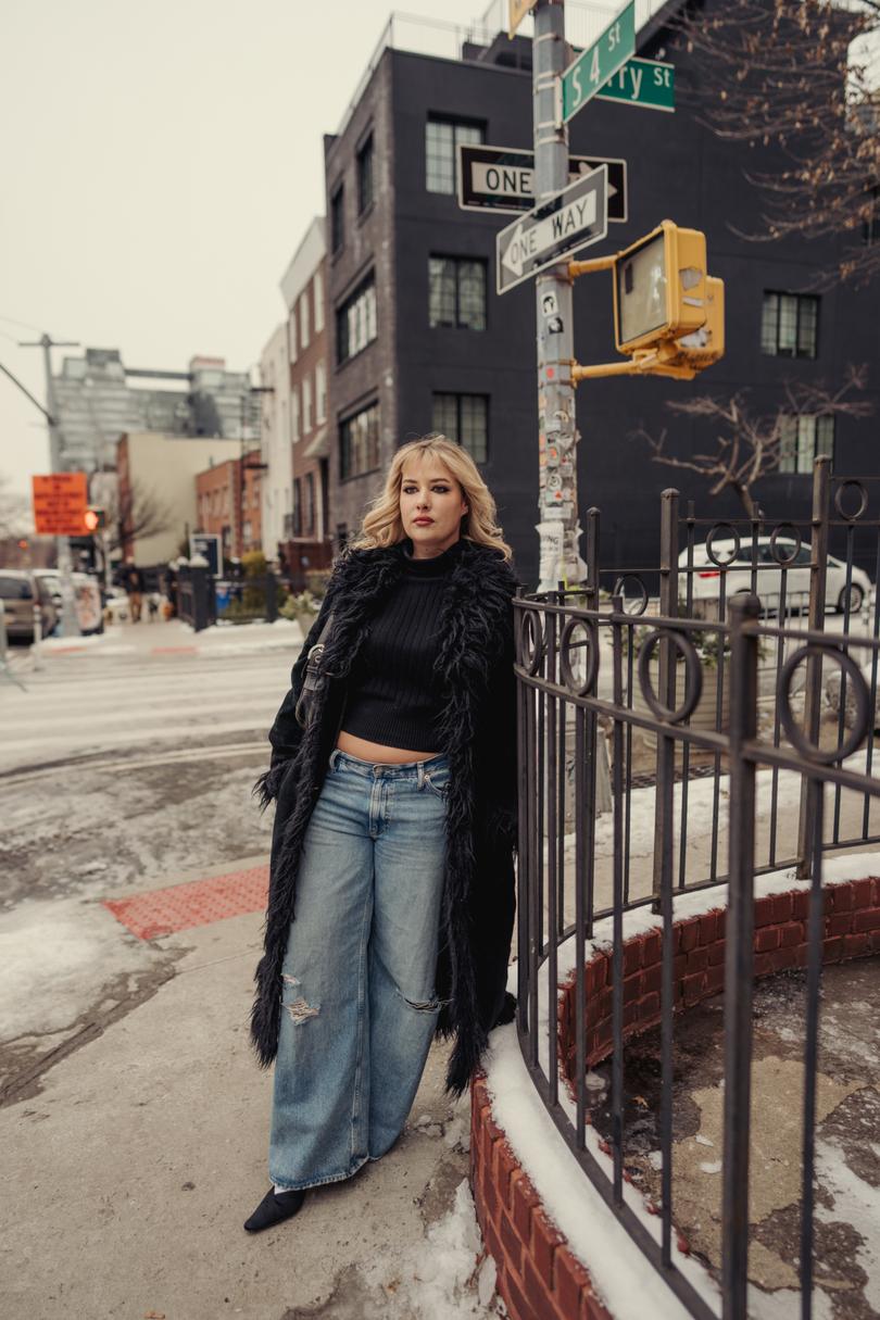 Kendall Hoyt, a digital creator who has three older millennial sisters, in a crop top and wide-leg jeans.