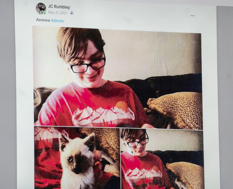 In this photo of a monitor screen, Ethan Crumbley is pictured with his cat Dexter, by his mother Jennifer Crumbley on her phone on May 31, 2021, as Jennifer Crumbley takes the stand in an Oakland County courtroom Thursday, Feb. 1, 2024, in Pontiac, Mich. Crumbley, the mother of the Michigan school shooter took the stand Thursday in her trial for involuntary manslaughter after the jury heard the teenager blamed his parents, including his father, James Crumbley, for not getting him help before the 2021 attack that killed four students. (Mandi Wright/Detroit Free Press via AP, Pool)