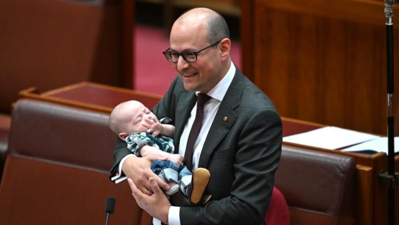 Labor senator Raff Ciccone holds his baby while in the Senate chamber.