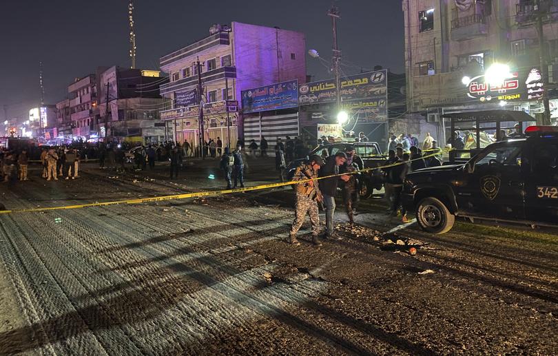 Iraqi federal police gather at the site of a burned vehicle targeted by a U.S. drone strike in east Baghdad, Iraq, Wednesday, Feb. 7, 2024. (AP Photo/Hadi Mizban)