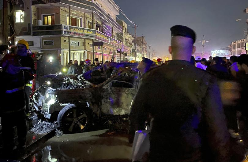 Iraqi federal police gather at the site of a burned vehicle targeted by a U.S. drone strike in east Baghdad, Iraq, Wednesday, Feb. 7, 2024. (AP Photo/Hadi Mizban)