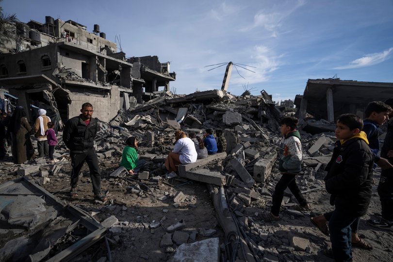 Palestinians inspect the damage to residential buildings where two Israeli hostages were reportedly held before being rescued.