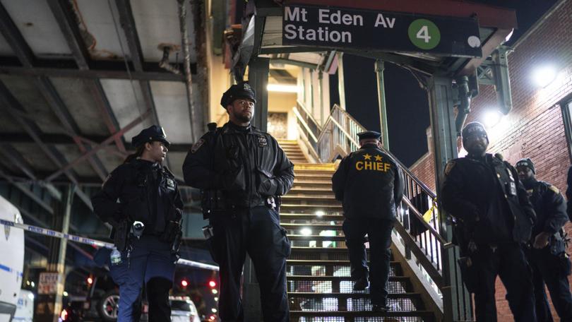 New York City Police officers stand guard following a shooting at the Mount Eden subway station.