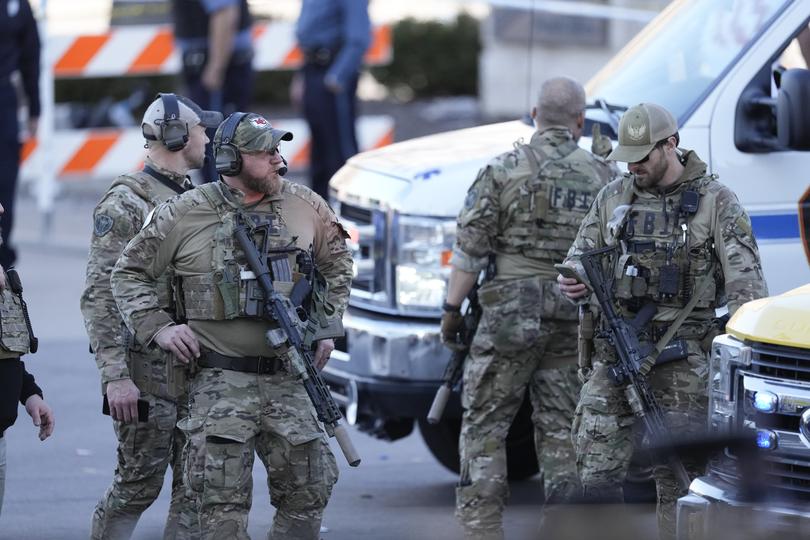 Dozens of uniformed police officers flooded the area with weapons drawn. Credit: Charlie Riedel/AP