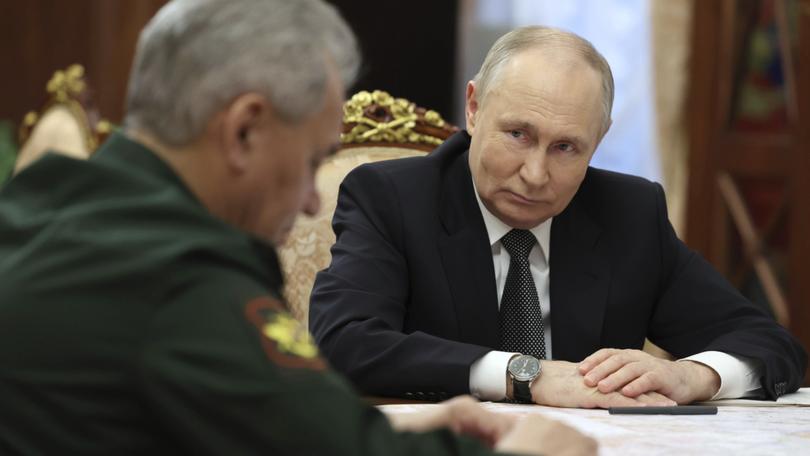 Russian President Vladimir Putin, right, listens to Russian Defense Minister Sergei Shoigu.