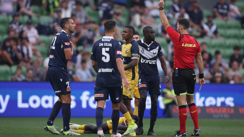 Referee Tim Danaskos shows Roderick Miranda of the Victory a red card after a contest with Mariner Alou Kuol.