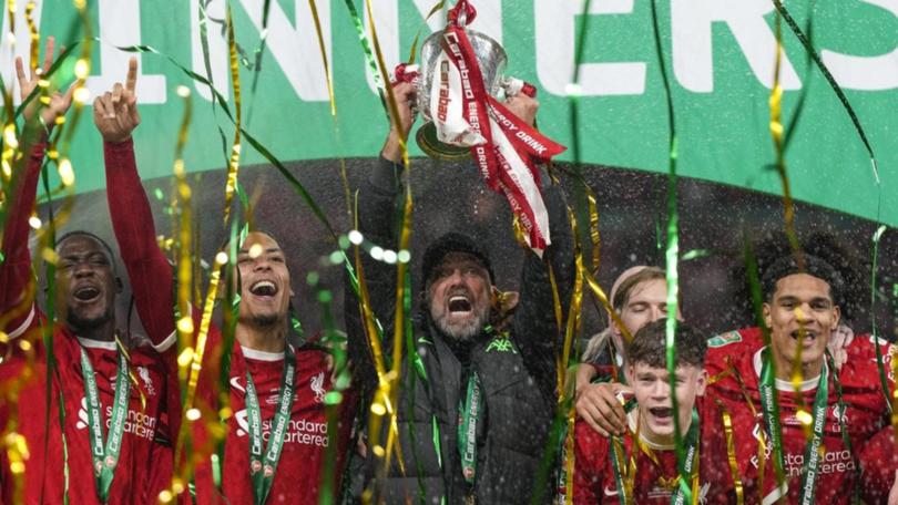 Liverpool manager Jurgen Klopp lifts the League Cup with his team after their Wembley win. (AP PHOTO)