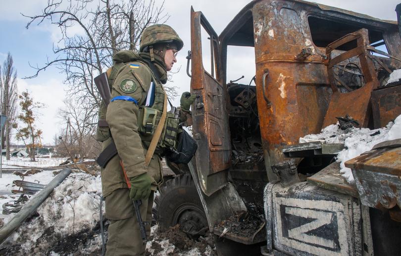 A Ukrainian National guard soldier inspects a Russian damaged military vehicle in Kharkiv, Ukraine, Wednesday, March 16, 2022. NATO Secretary-General Jens Stoltenberg made it clear Tuesday that the 30-nation military alliance is set to radically change its security stance in Europe in response to Russia's war on Ukraine. (AP Photo/Andrew Marienko)