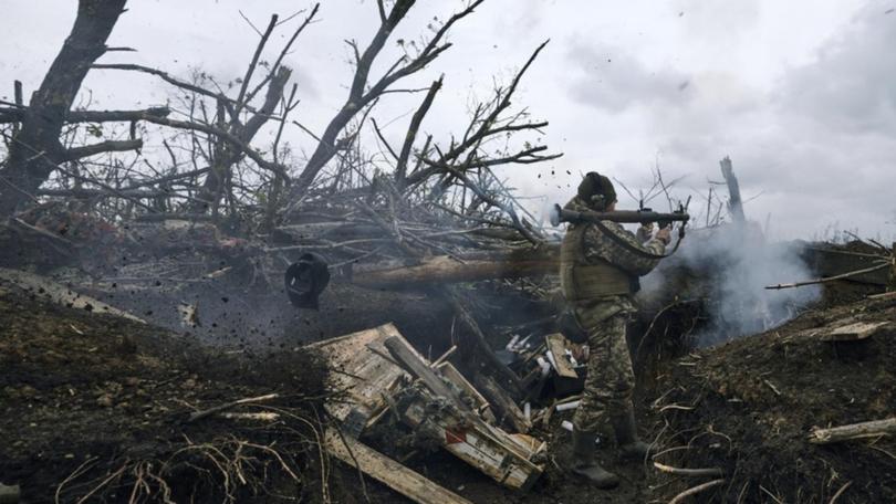 A Ukrainian soldier fires an RPG toward Russian positions