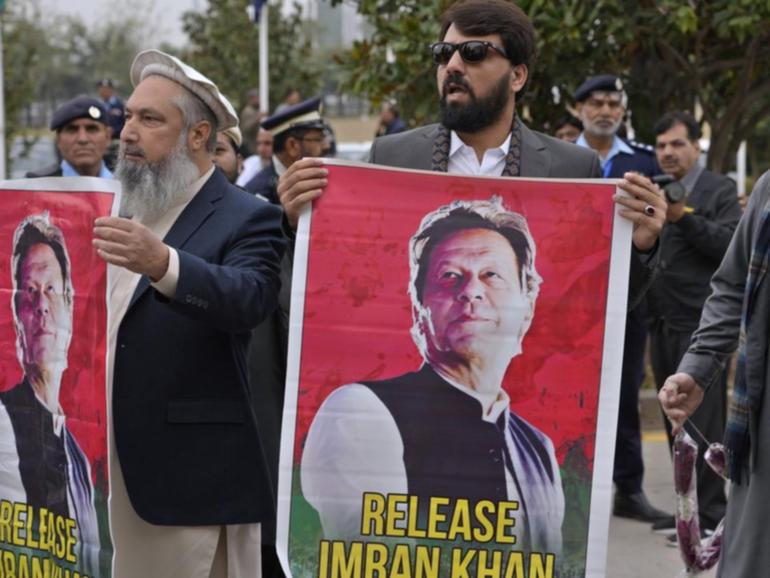 MPs have waved posters of their jailed leader Imran Khan as they arrived at parliament. (AP PHOTO)