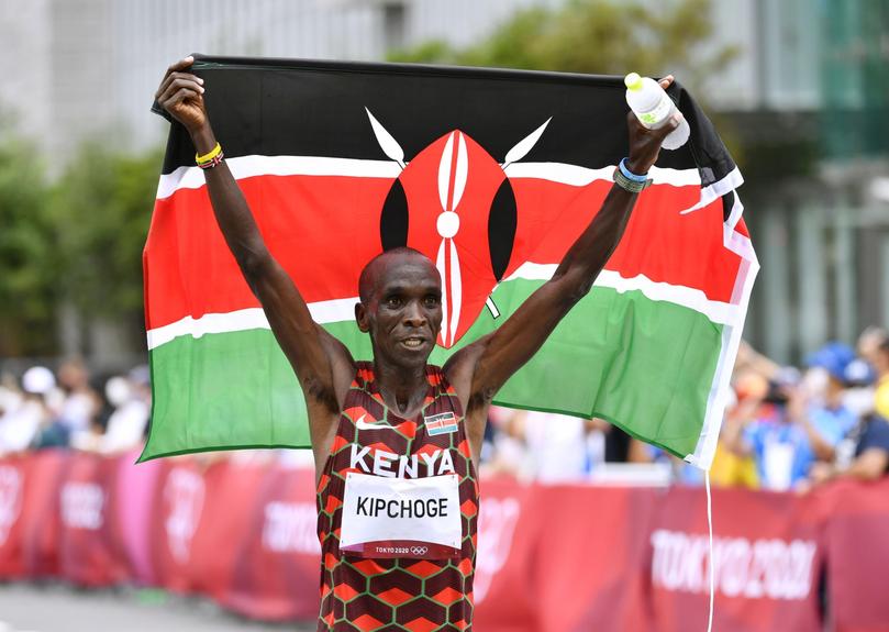 Eliud Kipchoge celebrates with the Kenyan national flag after winning the men's marathon at the Tokyo Olympics on Aug. 8, 2021, in Sapporo, northern Japan. (Kyodo via AP Images) ==Kyodo