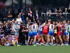 Players remonstrate as Jy Simpkin of the Kangaroos lays injured due to a high bump.