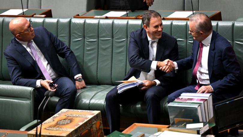 Anthony Albanese and Jim Chalmers shake hands as Peter Dutton looks on.