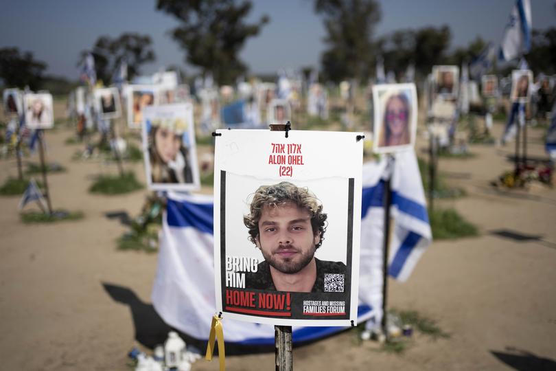 A poster depicting Israeli hostage Alon Ohel is displayed in Re'im, southern Israel at the Gaza border, Monday, Feb. 26, 2024 at a memorial site for the Nova music festival site where he was kidnapped to Gaza by Hamas on Oct. 7, 2023. (AP Photo/Maya Alleruzzo)