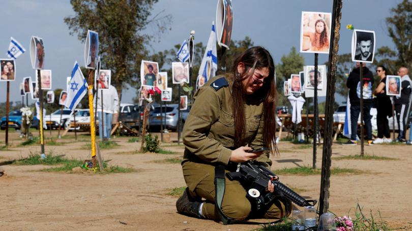 An IDF member next to a memorial of her family members at the site of the Nova festival. A UN team now believes sexual violence occurred in Hamas’s attacks on October 7.